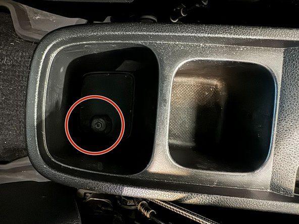 Use a Philips-Driver to remove the bolt in rear cavity of console.