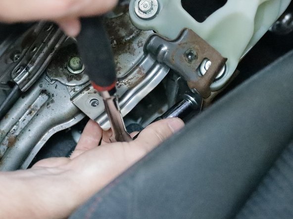 Use a 10m socket and remove the steel bracket located behind the shifter.