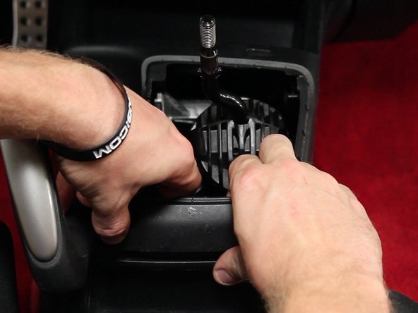 Gently unsnap the rear section of the console and remove it to expose the shifter assembly.