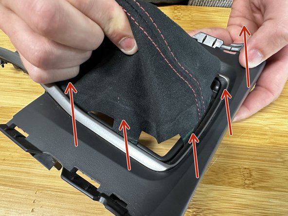 Flip the console cover over and pull the factory fabric out. It should slide out easily.