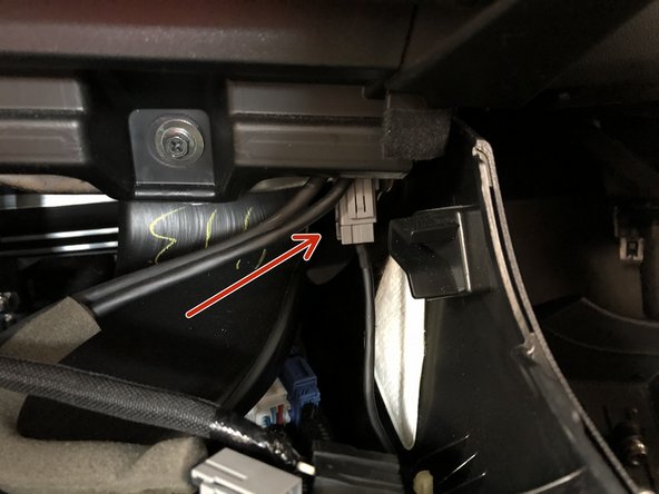 Locate and disconnect the gray electrical connector near the front RH corner of the console.