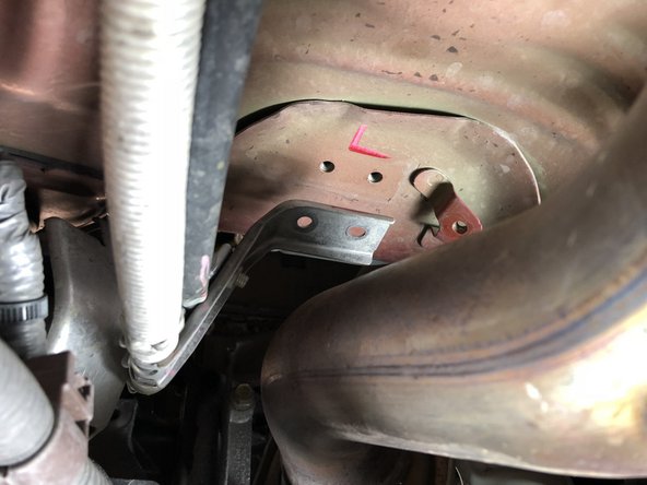 Once the heat shield is out of the way, located the 10mm nuts and bolts holding the shifter cables in place.