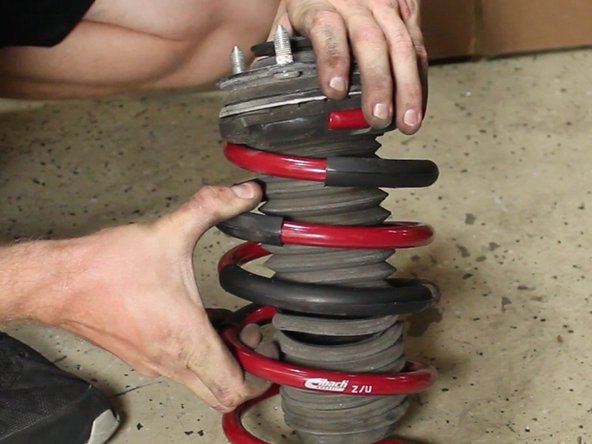 Install the upper strut mount to the new lowering spring just as it was removed from the factory spring.