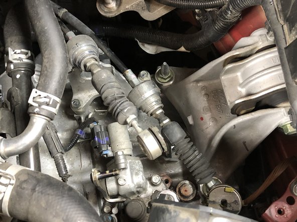 Remove the shifter cable pins and slide the cables off the transmission.