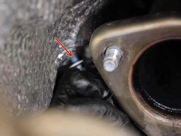 Remove the heat shield bolts and slide it out of the way, exposing the shifter cables.