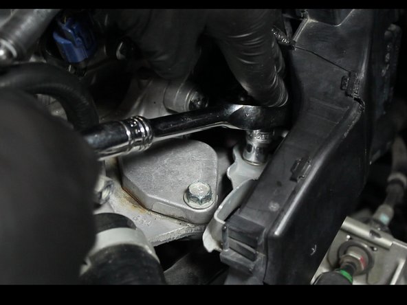Remove the wiring harness bracket from the coolant housing.