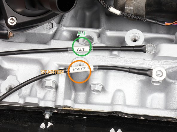 Land the heavy cable labeled STARTER, the starter battery feed, on the starter post with its M6 ring (the orange STARTER ring in the second photo marks the post). It is 8 AWG. Tighten the nut, then seat the boot back over the post.