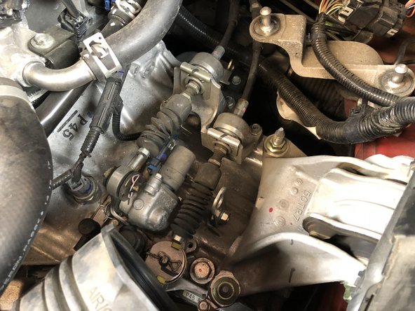 Using both hands, pull up on the airbox to remove it from the rubber mounts. This will expose the shifter cables.