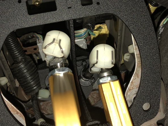 Spread the metal clips apart and slide the end link onto the shifter cup.