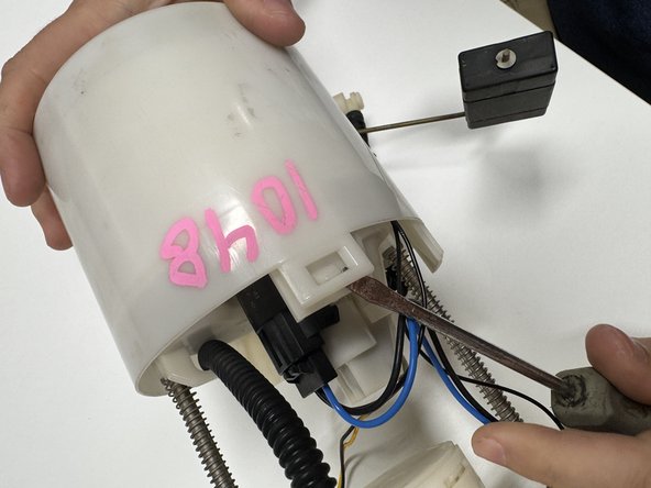 Unclip the lower fuel pump cover. There are a few clips that surround the top section. Unclip one and work your way around the case.