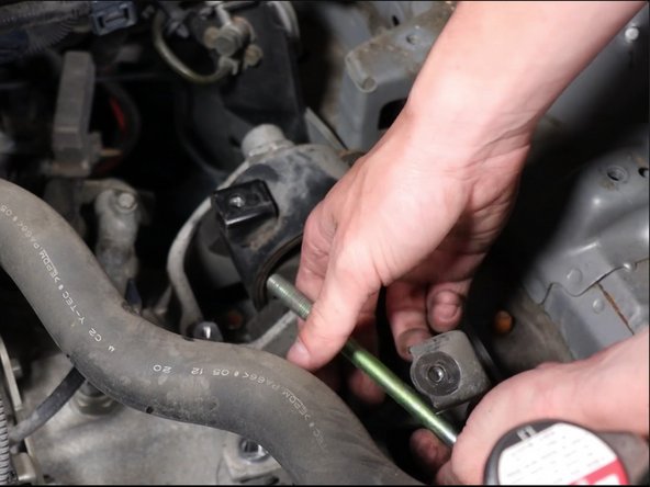 Be sure the transmission is fully supported before removing this bolt.