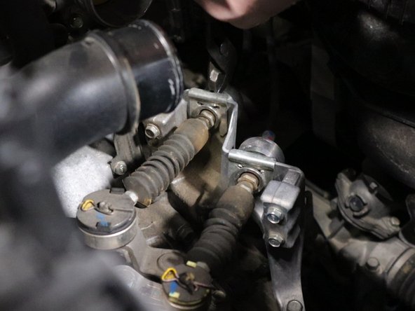 Remove the shifter cable spring clips from the transmission bracket.