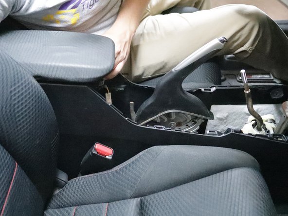 Remove the console from the car and set it aside.