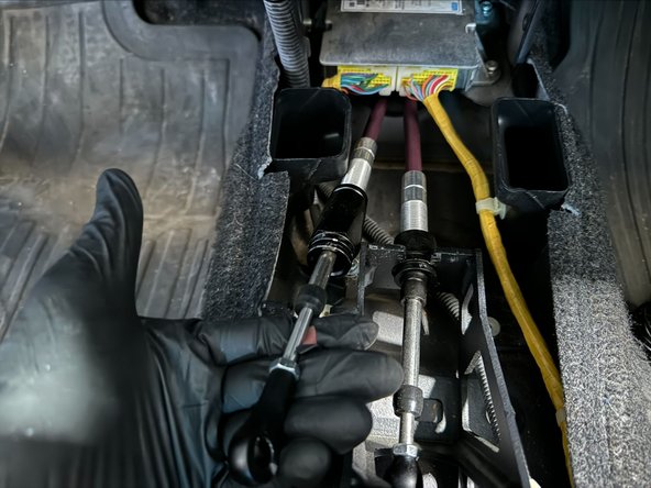 After cables disconnected from shifter, push cables into the Exhaust-Tunnel. This will also pop the Chassis Grommet loose.