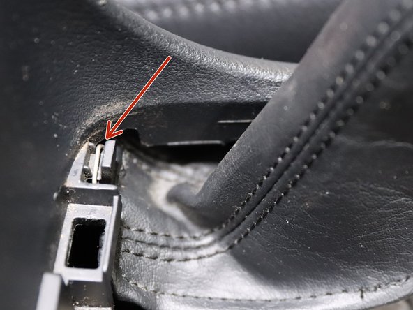 Remove the e-brake boot cover from the console. There is a small metal ring hooked around the top section.
