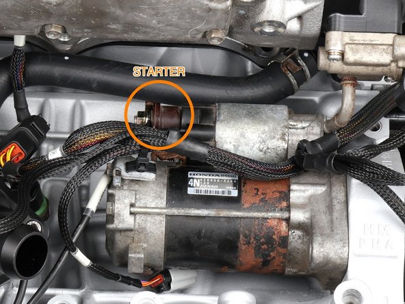 Connect the small starter solenoid wire (labeled ST) at the starter solenoid. Its small boot sits beside the main post; go by the printed ST tag.