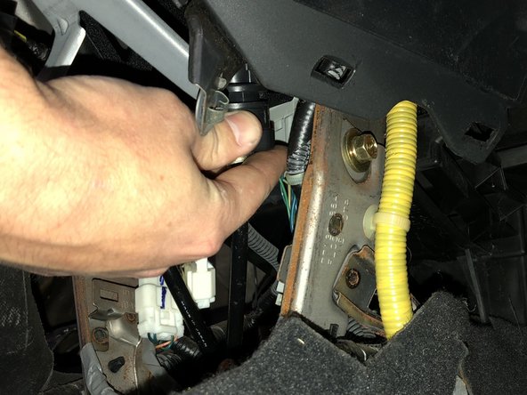 Install the shifter cables into the shifter base by rotating and sliding them in through the side.