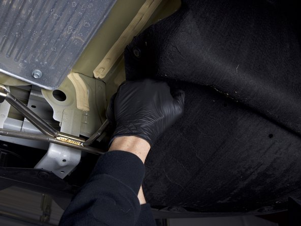 We suggest just installing one hanger through the bushings at a time. Once you have one hanger in each bushing, you can rotate the rubber and get the other one through.