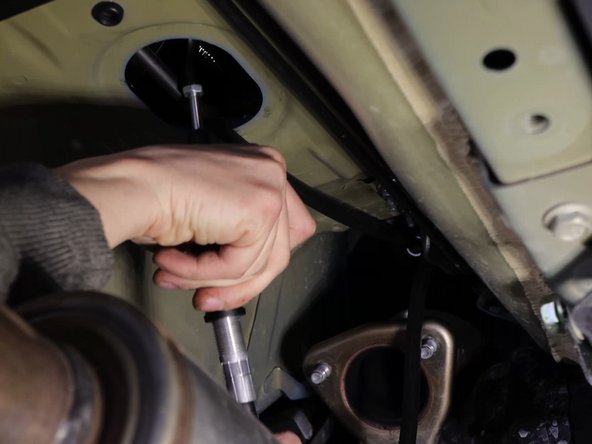 Then bend the cables upwards and slide them through the hole in the floor. You can now attach the bracket and slide the rubber grommet in place.