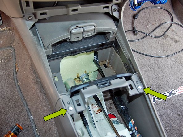 Using the same Phillips head screw driver remove the next set of screws just below the first ones in front of the shifter.