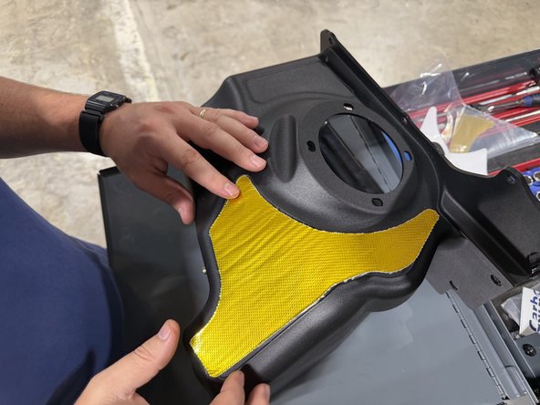 Peel the backing carefully and press it into the spot outlined on the intake box.