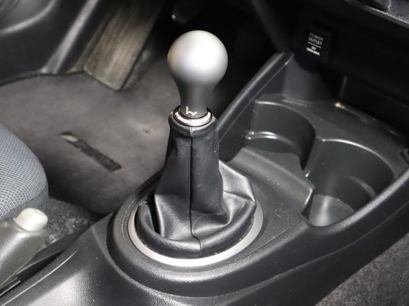 Depending on how you adjust the shifter, the offset / front wishbone may contact the stock shift boot surround. The console has slotted holes so you can loosen the screws and push the console as forward as it will go and then tighten the screws. That should give a few  more millimeters of clearance.