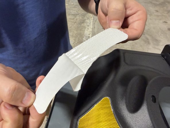 Grab the smaller heat strip, peel off the backing, and press it into its outlined shape on the intake box.