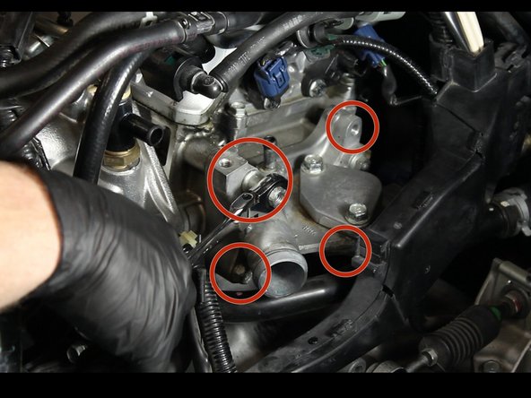 Remove the two upper nuts and two lower bolts.