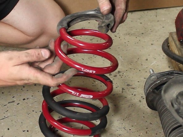 Install lower rubber spring seat on the bottom of the new lowering spring.