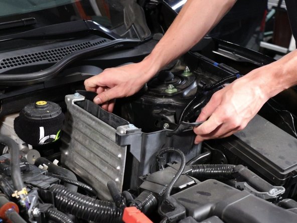 Remove the battery from the car. Then, remove the battery isolator.