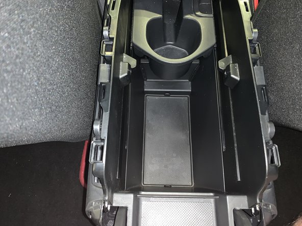 Remove the two screws inside of the center console.