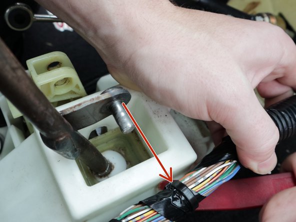 Use a pry tool and remove the wire harness clip from the shifter.