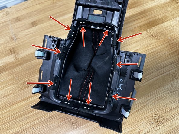 Locate the shift boot fabric on the inside section of the console cover. The factory fabric is attached with staples and tape.