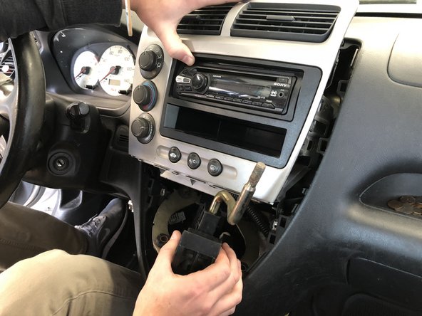 Remove the shifter assembly by pulling the center dash section outwards and upwards. Hold it out of the way to give you more room to pull the shifter out.