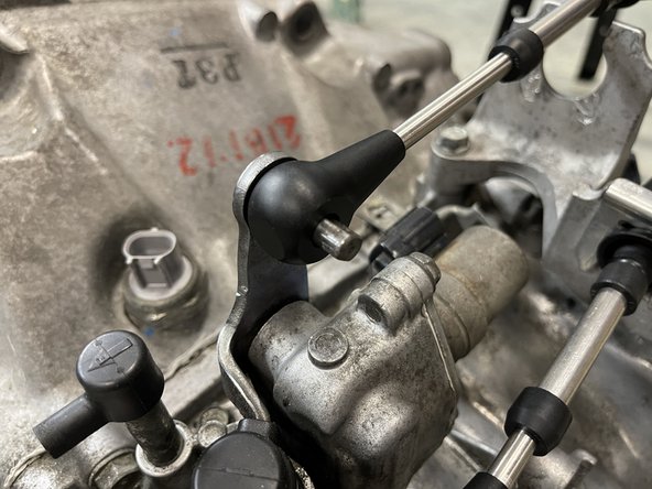 Install the shifter cable onto the gear selector pin.