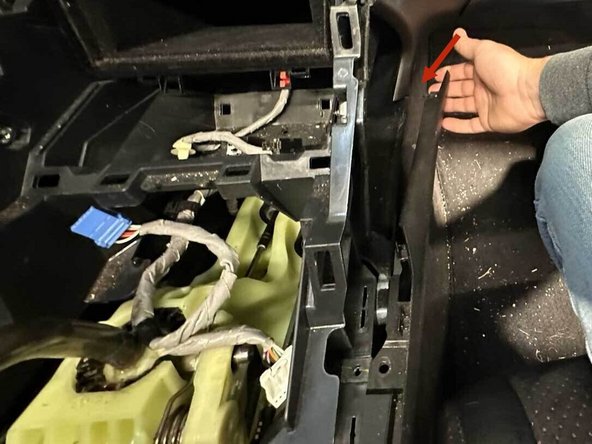 There are two panel clips here. Gently pull both sides until they release. Then move to the back of the car to finish the removal of the center console.