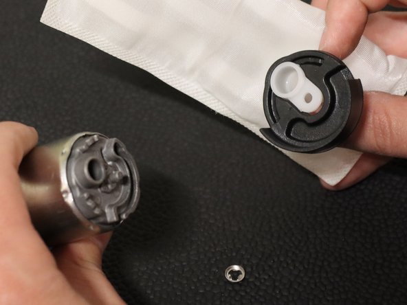 Use a flat-tipped screw driver or pry tool and remove the metal retaining clip holding the pick-up filter in place.