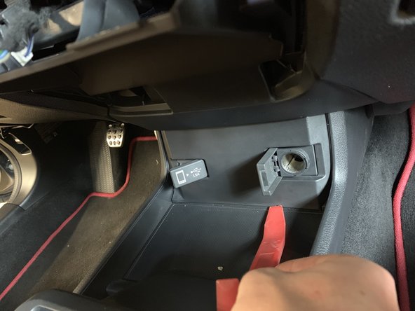 Use a plastic panel pry tool on the lower section of the console cover.