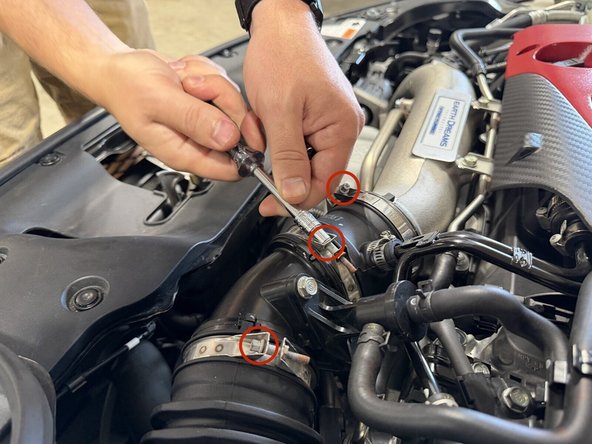 Loosen all of the hose clamps on the intake and inlet tubes. The stock clamps take a 5.5 mm socket or a flathead.