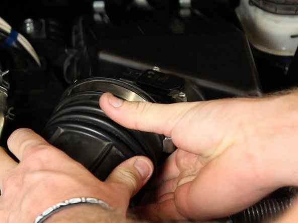 Pull the air intake tube back and slide it off of the air box lid.