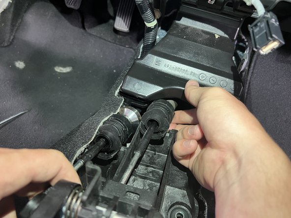 Then rotate the shifter cable and slide it upward, removing it from the shifter base.