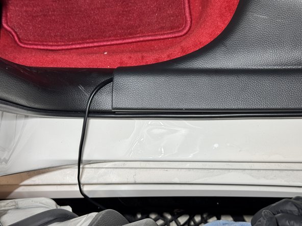 Once the harness slides under the rear sill panel, pull it through and run it along the driver side.