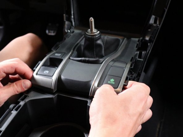 Then grab the back section and pull upwards; this should unclip the shift boot cover.