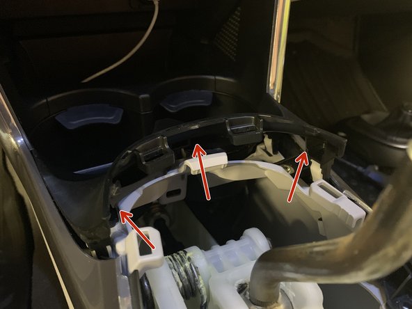 Remove the plastic trim near the cup holders. Use your fingers to pry it up and the clips will pop free.