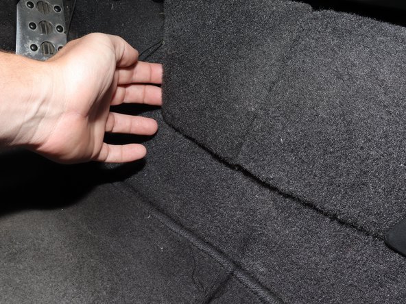 On the left-hand side of the lower kick panel, remove the panel to reveal the mounting bracket.