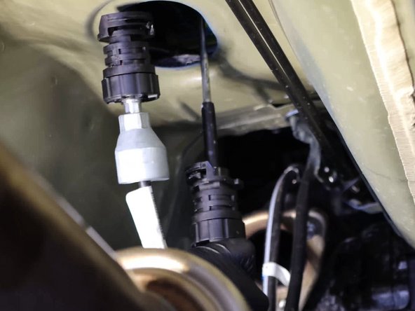 Pull the rubber seal down and remove the shifter cables from the cabin.