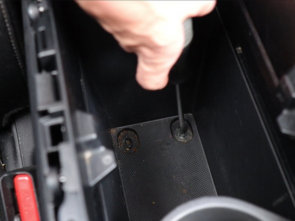 Then, inside of the armrest, under the bottom pad, remove the two screws.