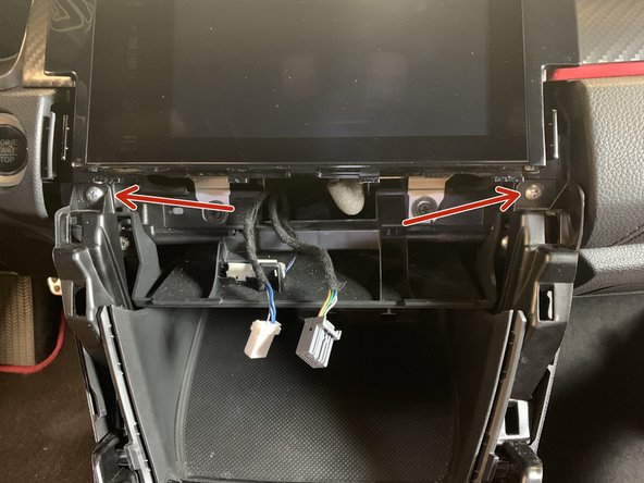 Use a #2 Phillips screwdriver to remove the two upper console screws.