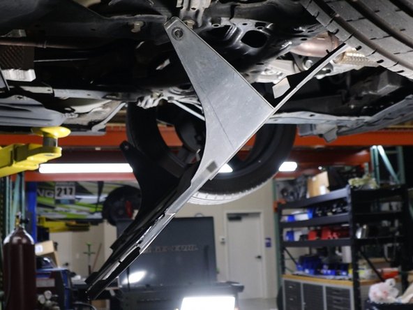 Once the aluminum tray has been removed, you can then unclip the rear section and let it hang down. It is not necessary to remove the entire panel.