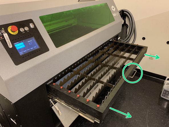 Open the front door of the machine once more, and pull the handle on the front of the work table until the table rolls out of the machine.